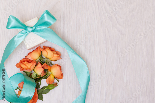 Creative mock up layout made of roses with copy space on table homemade flat lay. Empty sheet of paper. Mockup with a card and orang rose