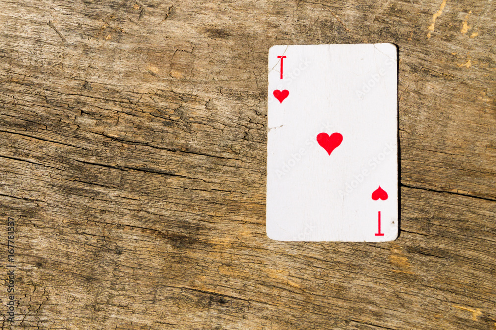 Ace of hearts on old wooden background