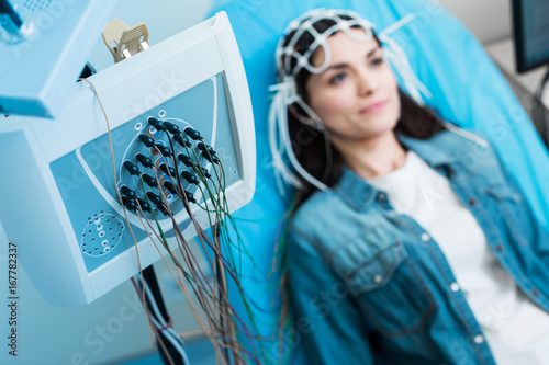 Billede på lærred Close up of electroencephalograph recording brain waves of woman