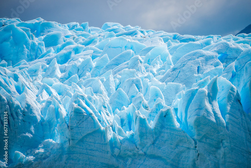 A close-up of the uneven surface of a blue glacier during the day. Shevelev.