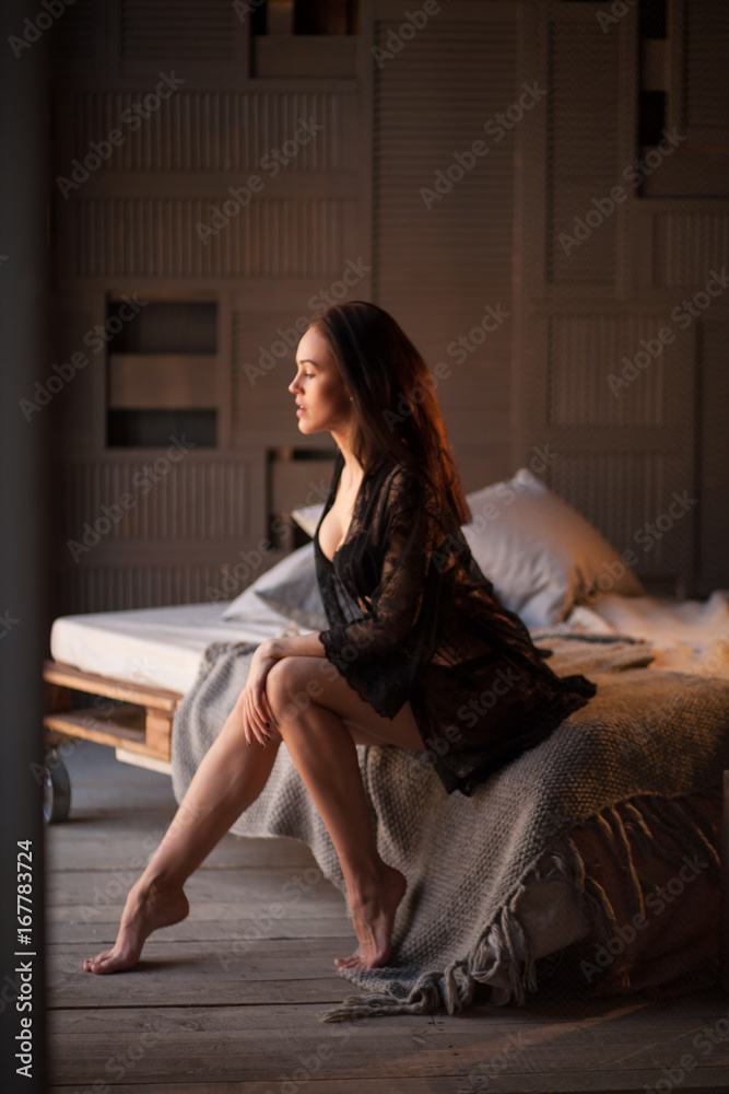 Fototapeta premium Sexy brunette woman posing in elegant lingerie, looking at camera. Girl with perfect body lying, relaxing.