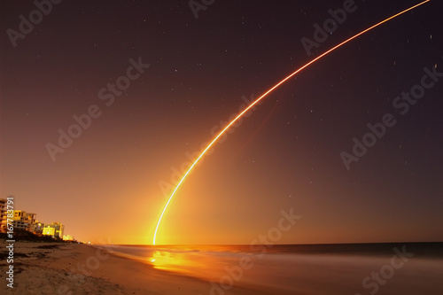 Fototapeta Naklejka Na Ścianę i Meble -  Space rocket lunch at the Atlantic Ocean shore in Florida at night.