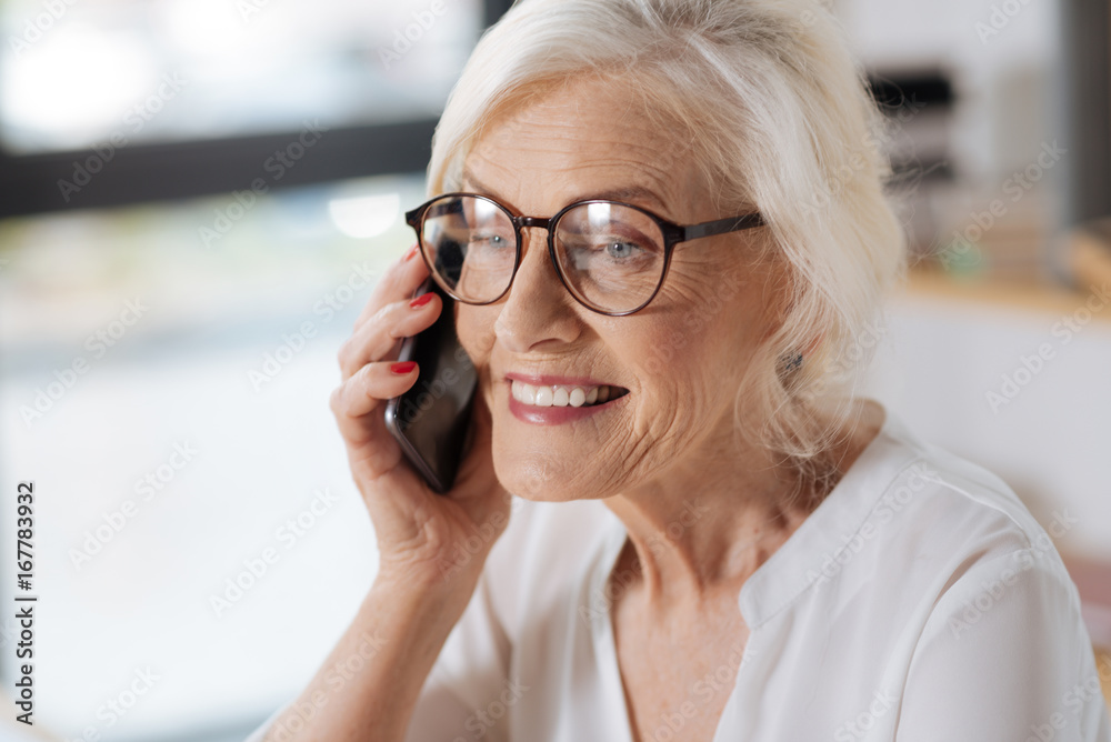 Joyful elderly woman having a phone conversation Joyful elderly woman having a phone conversation