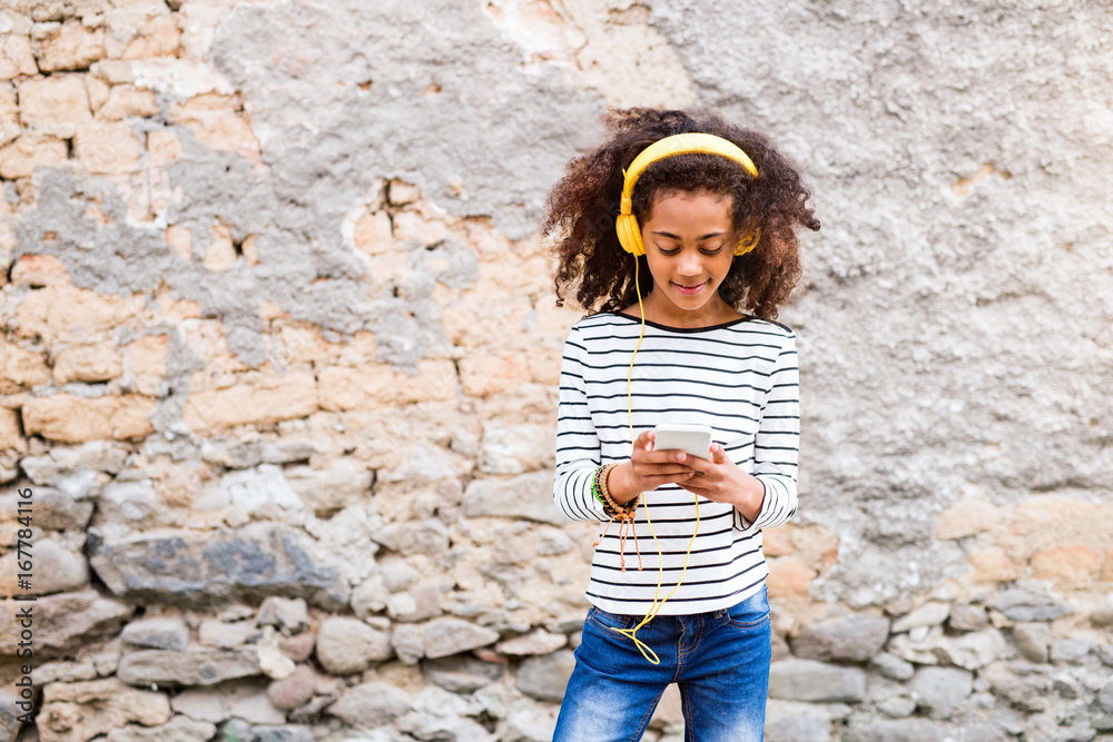 Beautiful african american girl with smart phone and earphones. Beautiful african american girl with smart phone and earphones.