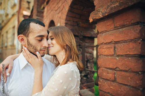 beautiful wedding couple hugging standing near old building © VAKSMANV