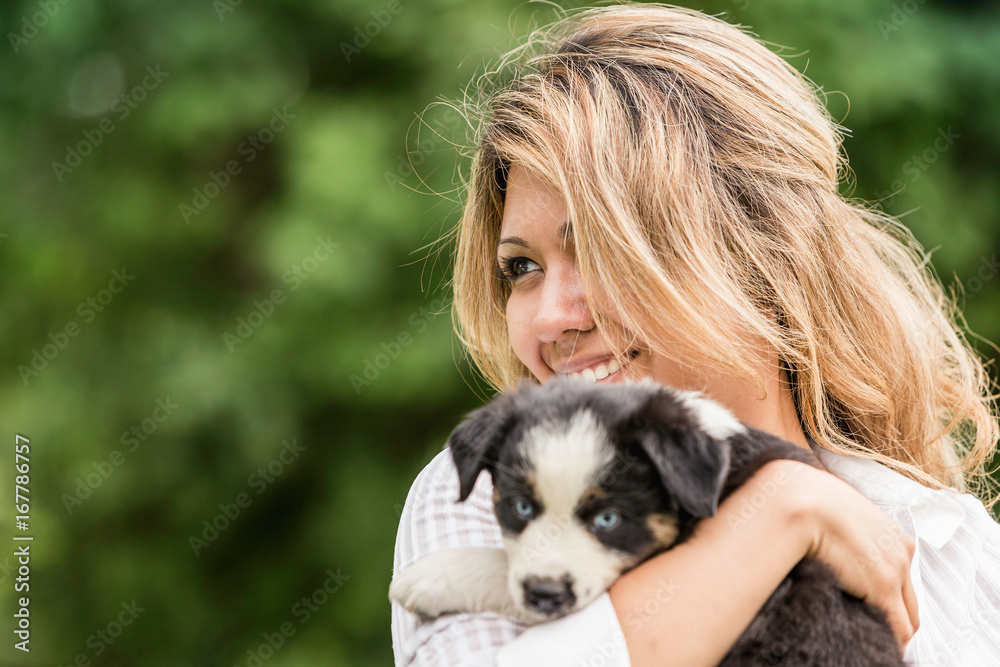 Young woman holding sheepdog puppy on ranch, Bridger, Montana, USA Young woman holding sheepdog puppy on ranch, Bridger, Montana, USA