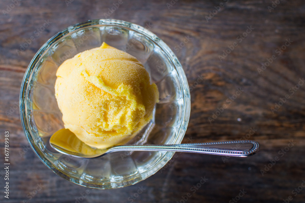 Glass bowl with tasty color ice cream on wooden table Glass bowl with tasty color ice cream on wooden table