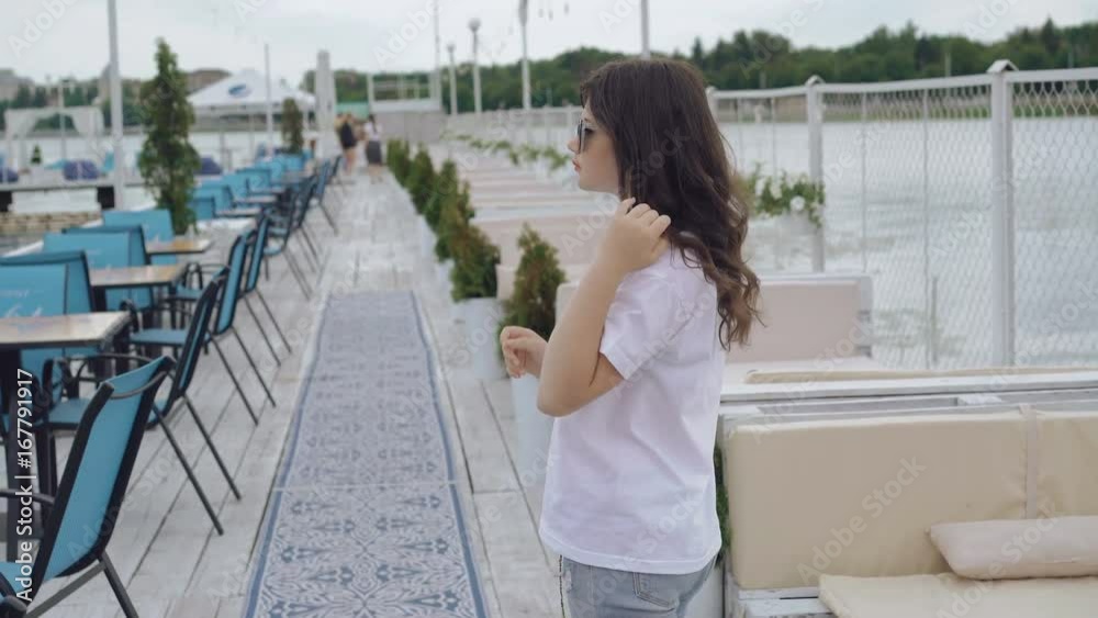 Young model stand in profile and puts on the sunglasses 4K Young model stand in profile and puts on the sunglasses 4K
