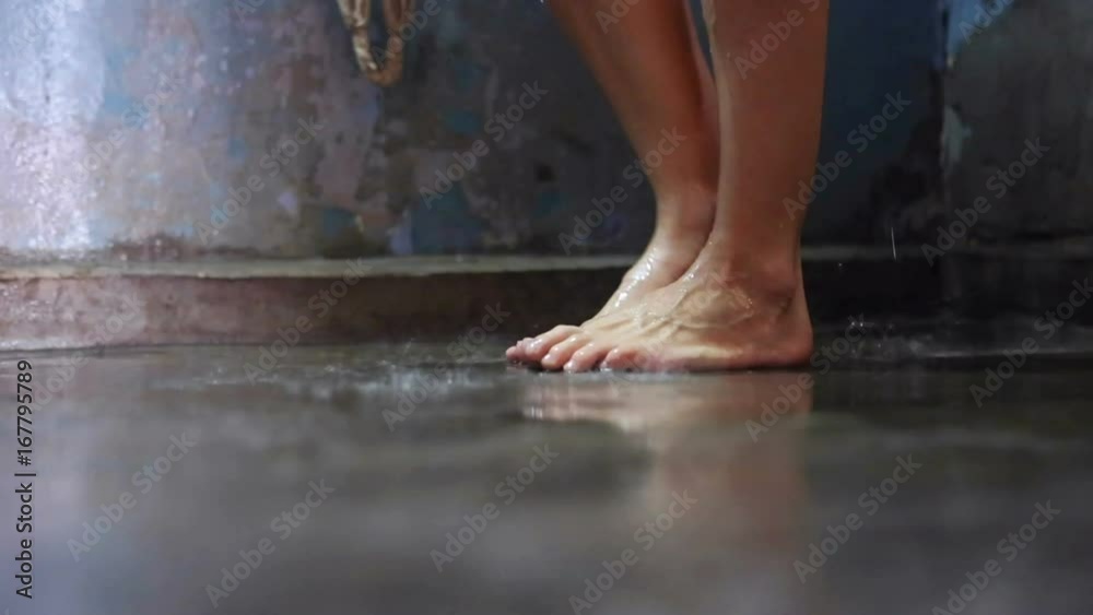 Female feet in shower room. A woman washing under shower