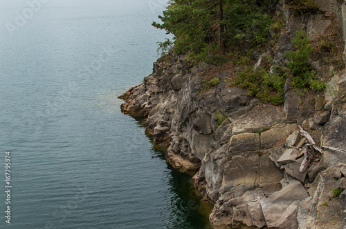 Fototapeta Naklejka Na Ścianę i Meble -  Skaliste zbocze wyspy przy wodzie, Jezioro Solina, Polska