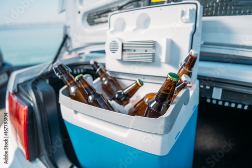 close up view of portable fridge with beer standing in car photo