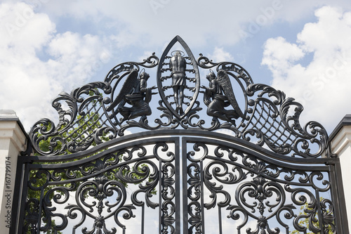 Wrought gates. Image of a decorative cast iron gates. metal gates close up. beautiful gates with artistic forging.Image of god and angels