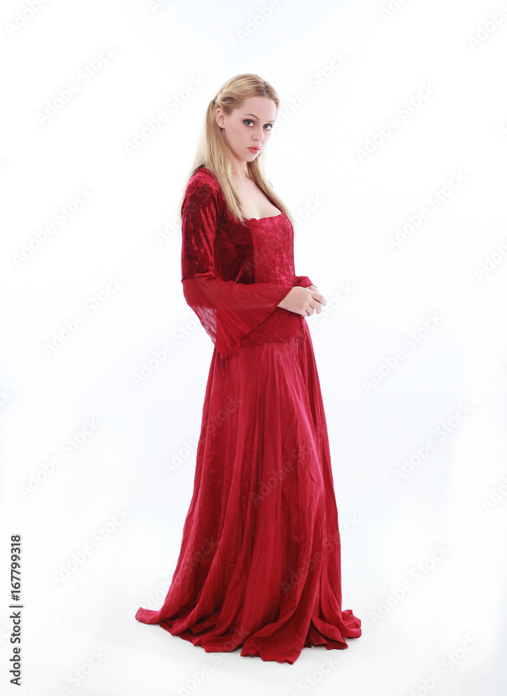 beautiful lady with long blonde hair wearing a red medieval fantasy gown. standing, isolated on white background.