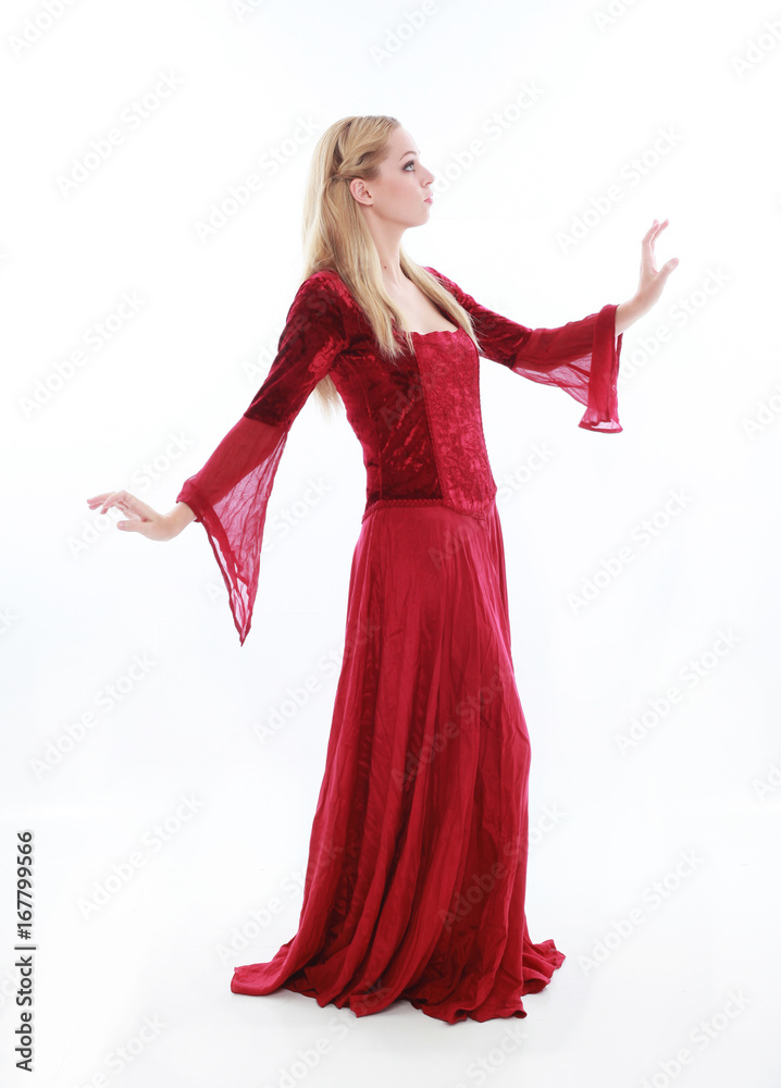 Naklejka premium beautiful lady with long blonde hair wearing a red medieval fantasy gown. standing, isolated on white background.