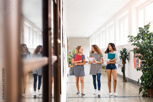 Teenage students walking in high school hall during break.