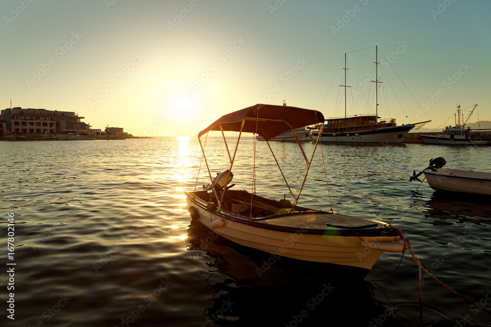 Small boats, fishing trawler and a sailboat moored in the harbor of a town Postira - Croatia, island Brac