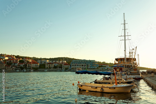 Boats and fishing trawler moored in the harbor of a small town Postira - Croatia, island Brac