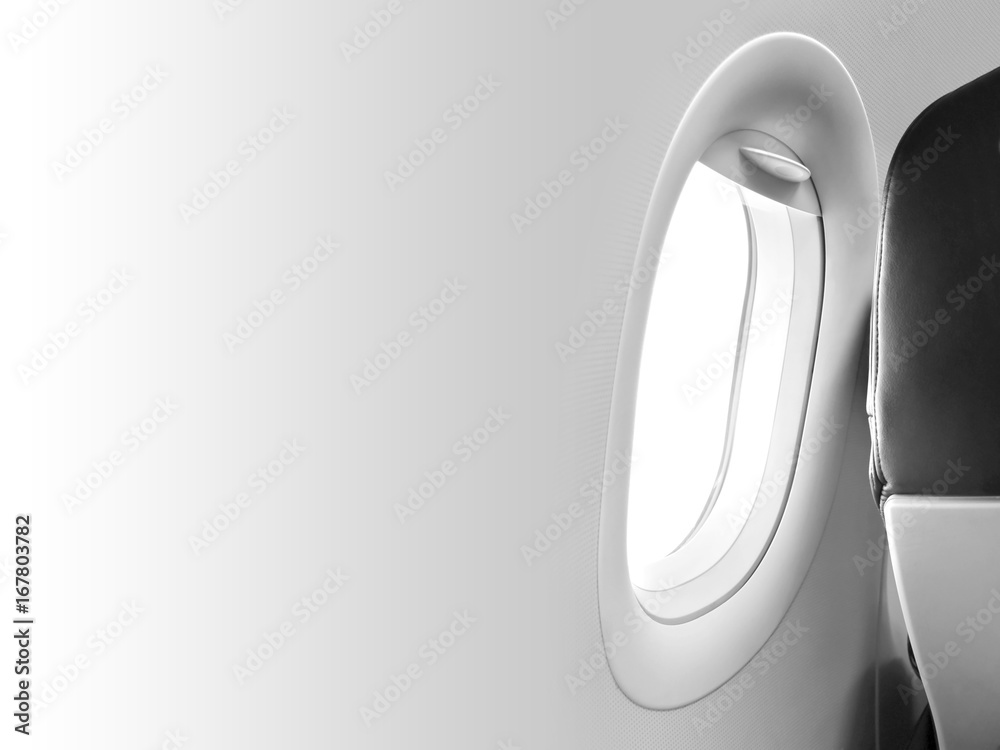 Fototapeta premium Gray aircraft window and backside of the passenger seat with black leather cover in the cabin crew, one airplane chair beside windowpane frame white background and blank space template