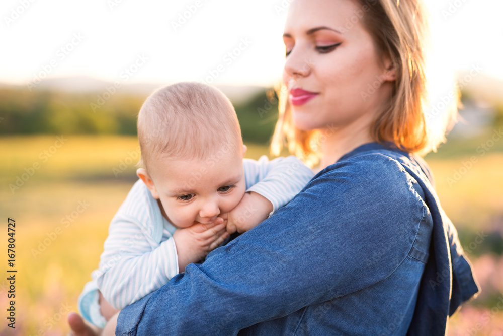 Young mother in nature with baby son in the arms. Young mother in nature with baby son in the arms.