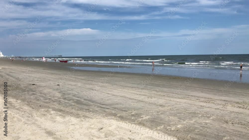 Beach with small ocean waves and people enjoying water Beach with small ocean waves and people enjoying water
