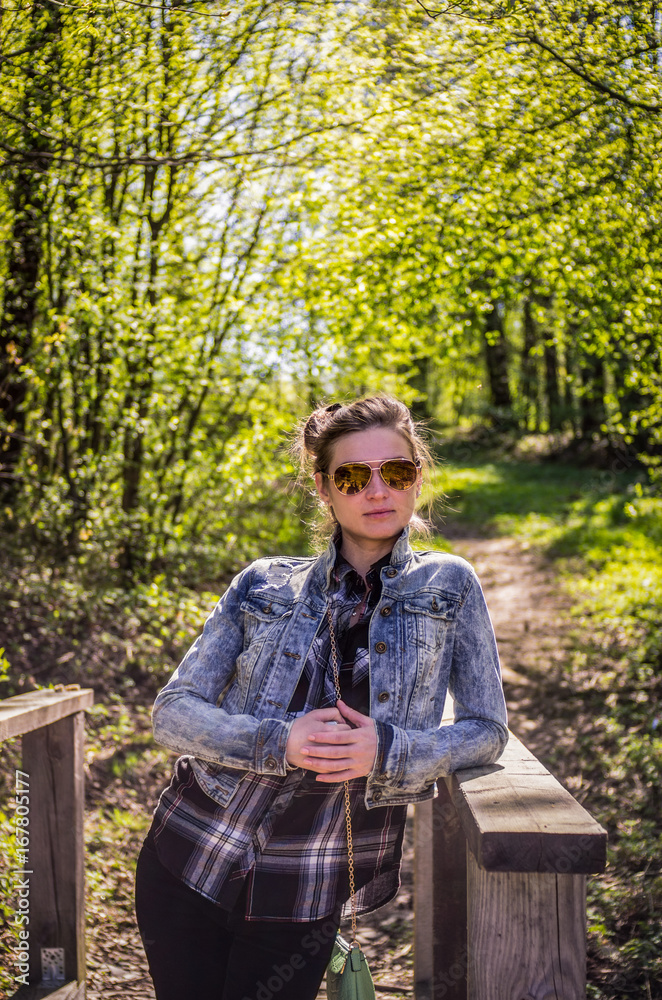 Fototapeta premium Beautiful blonde woman in sunglasses on nature background