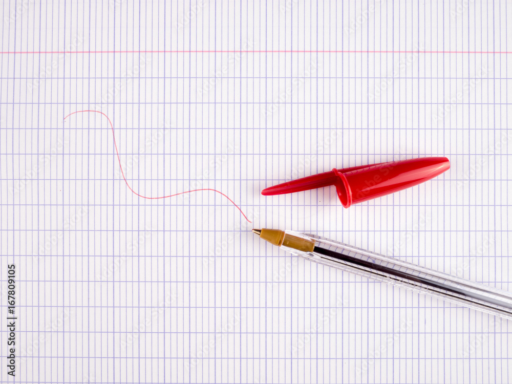 Red ballpoint pen on a large checkered sheet Red ballpoint pen on a large checkered sheet