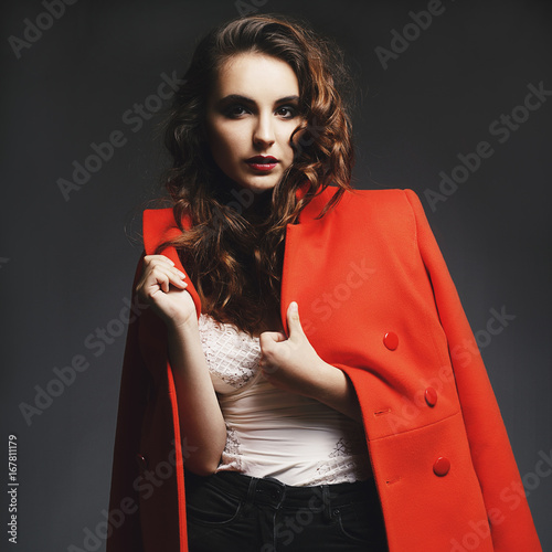 Beautiful young woman posing in studio over grey background. Fashion concept.