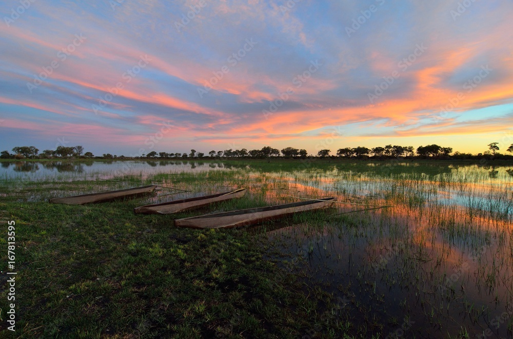 Mokoro in the Okavango delta at sunset, Botswana