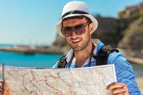Portrait of a smiling tourist with map and bag