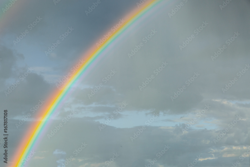 Rainbow seen close up at sunset on a cloudy day Rainbow seen close up at sunset on a cloudy day