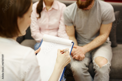 Family psychologist consulting young couple in trouble photo