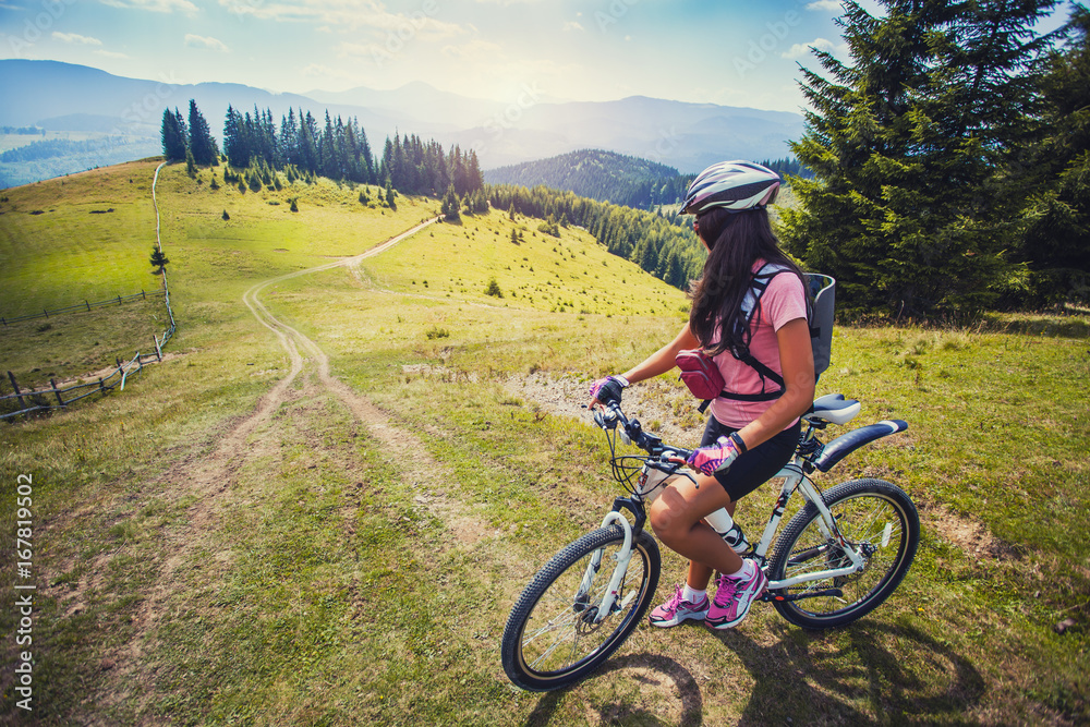 young woman riding a bicycle on the high plateau