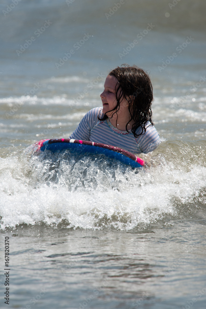 Girl surfing the waves in the ocean on a boogy board Girl surfing the waves in the ocean on a boogy board