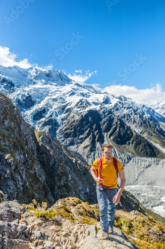 Hiking hiker man tramping in New Zealand mountains. Alpine trekking lifestyle mountaineering excursion with snow capped mountains landscape.