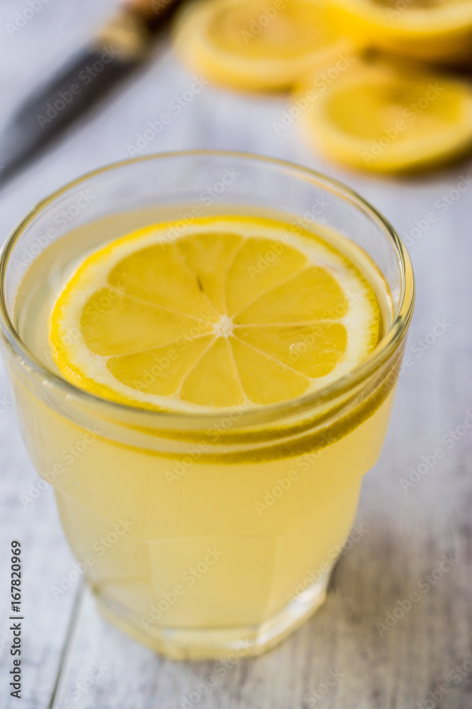 Lemon Liqueur Limoncello with lemon on white wooden surface. Lemon Liqueur Limoncello with lemon on white wooden surface.