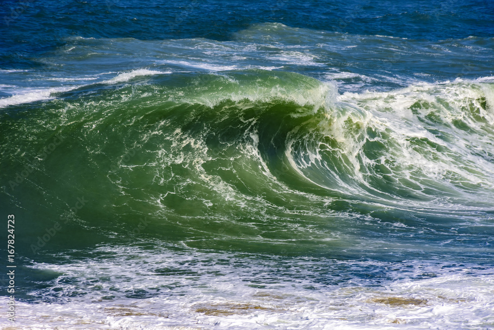 Fototapeta premium Big, dangerous waves during tropical storm in the green and blue waters of Rio de Janeiro, Brazil