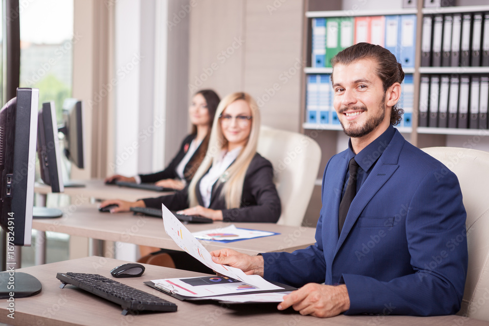 Business person working in office next to colleagues Business person working in office next to colleagues