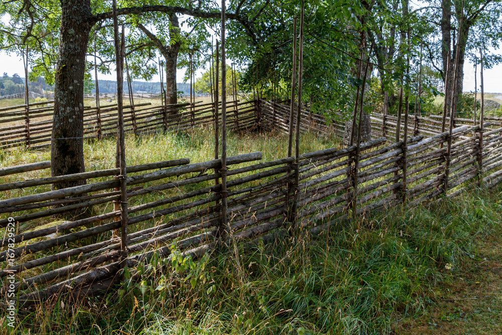 Traditional old wicker fence in countryside of Sweden Traditional old wicker fence in countryside of Sweden