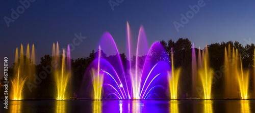 Multicolored musical fountain on a lake at night