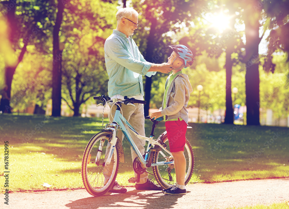 Obraz premium grandfather and boy with bicycle at summer park
