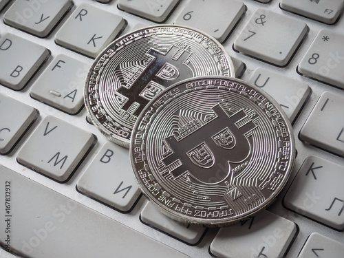 Digital currency physical metal bitcoin coin on the keyboard.