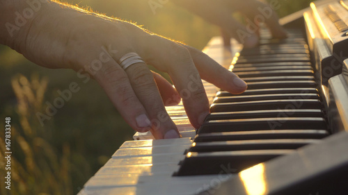 Fotografía Musician Playing The Electric Piano On The Sunset, Closeup