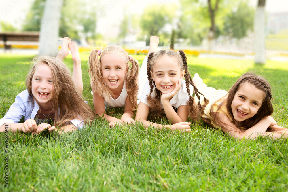 little girls of the girlfriend laying on grass and Having Fun outdoors in summer little girls of the girlfriend laying on grass and Having Fun outdoors in summer