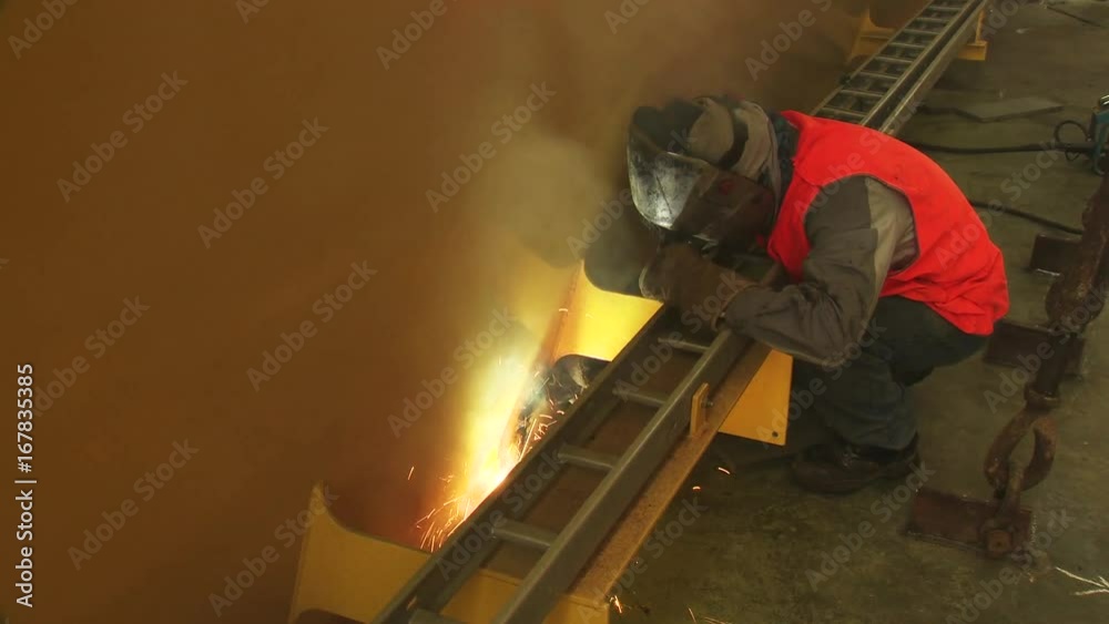 Worker uses welding torch on steel beam Worker uses welding torch on steel beam