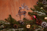 brown wooden background with Christmas design with spruce branches, pine cones, Christmas tree with toys, glass balls and toy deer