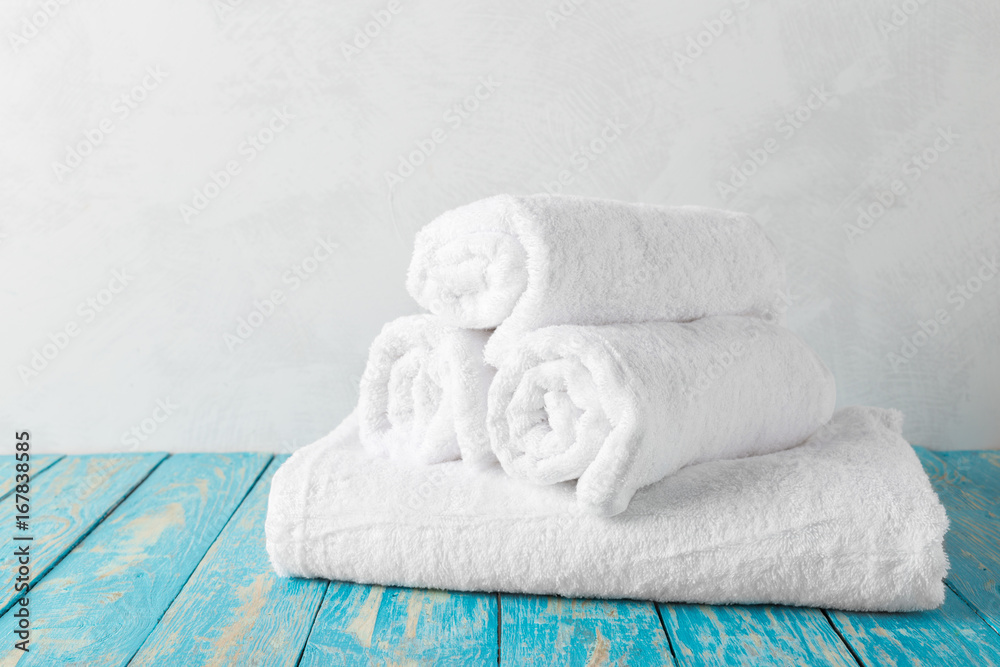 Stack of bath towels on wooden table with copy space Stack of bath towels on wooden table with copy space