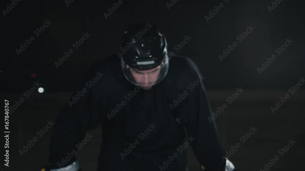 Handsome hockey player. Smiling at camera on dark arena, close up portrait of defender or forward canadian player Handsome hockey player. Smiling at camera on dark arena, close up portrait of defender or forward canadian player