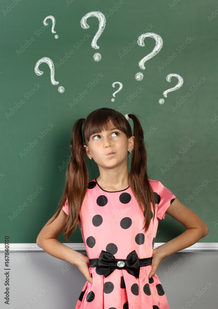 Child girl with question mark on school blackboard