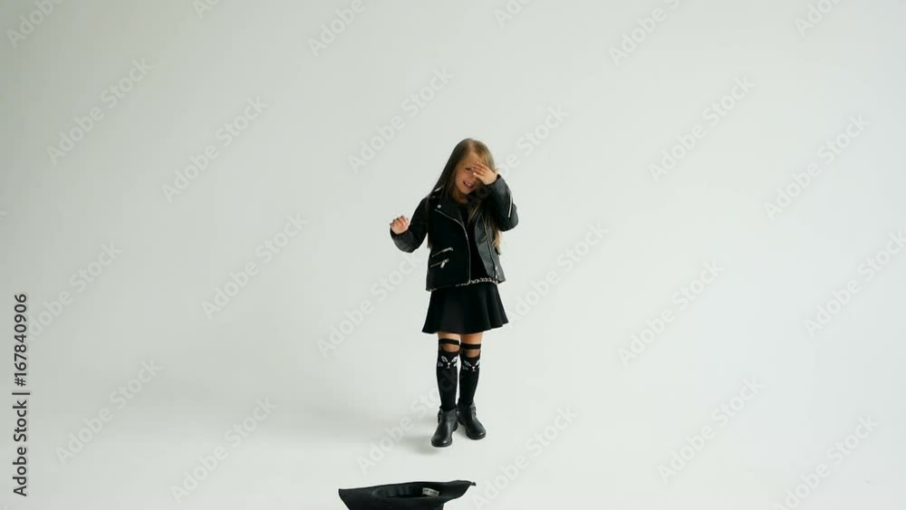 little girl in rocker style throws hat over white background little girl in rocker style throws hat over white background