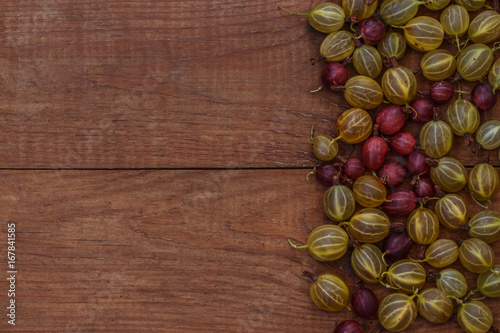 brown wooden background with green and red gooseberries